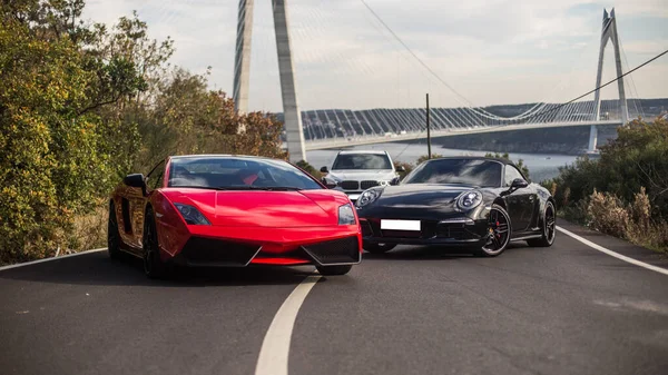 Vermelho, preto e branco carros esporte estacionamento na vista ponte — Fotografia de Stock