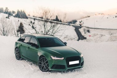 Karlı bir ormanda yeşil spor model off roader, ön manzara