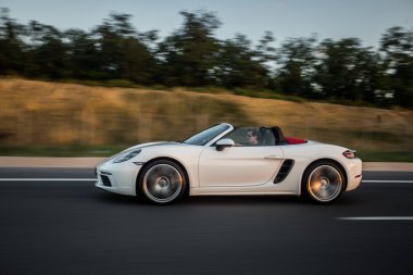 Beyaz süper model Cabriolet araba otobanda, dağlık alanda, profil manzaralı.