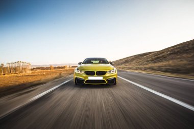 Yeşil lüks sedan araba. Yüksek hız. Tepeler boyunca otobanda, ön manzara.
