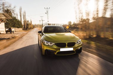 Sarı renkli hatchback yolda gidiyor, ön manzara