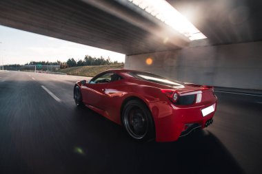 Köprünün altından kırmızı lüks model spor araba manzarası