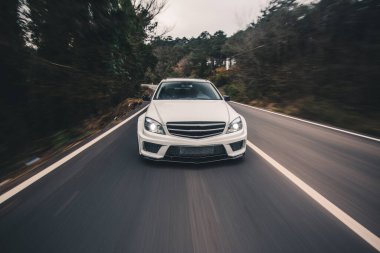 Beyaz ksenon ışıklarıyla beyaz off road aracı, Akşamları ağaçların arasından orman gezintisi