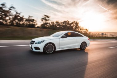 Günbatımında beyaz lüks araba