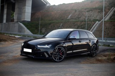 Köprünün altına park edilmiş siyah bir araba.