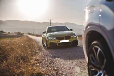 İki sedan araba yola park ediyor.