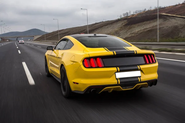 Carro modelo esporte amarelo na estrada com afinação preta — Fotografia de Stock
