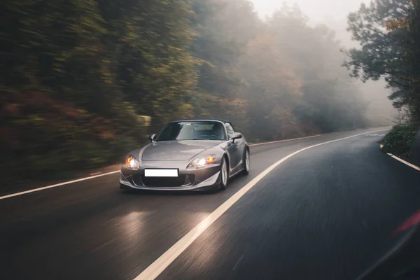 Silver sport car in the forest in the rain — Stock Photo, Image