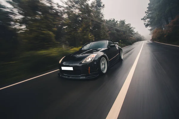 Driving in the rainy weather in the forest with front lights on — Stock Photo, Image