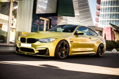 Modern bir mimari binanın önündeki sarı spor model araba, ticari çekim.