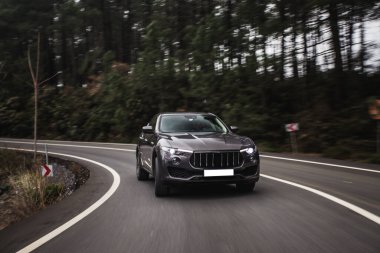 Karanlık ağaçların arasından ormanda siyah bir off-road aracı.