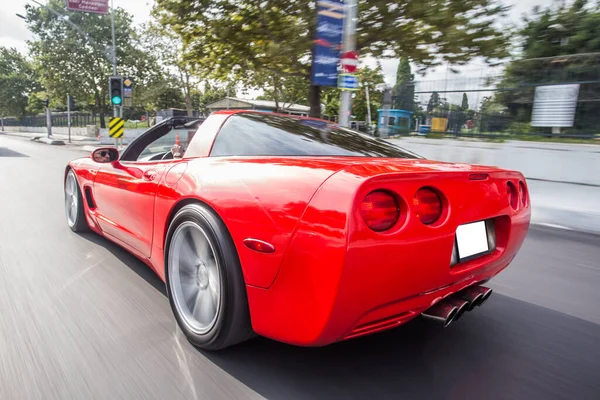 Red coche deportivo de alta velocidad conducir a través de árboles verdes — Foto de Stock