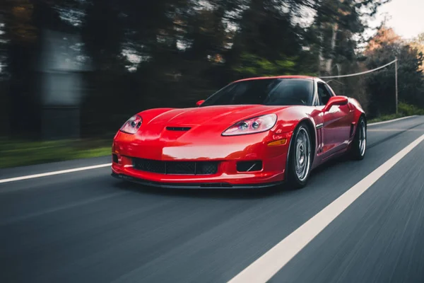 Red luxusní sportovní auto na lesní dálnici — Stock fotografie
