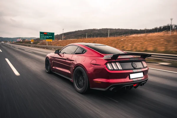 Carro modelo esporte vermelho na estrada através das colinas — Fotografia de Stock