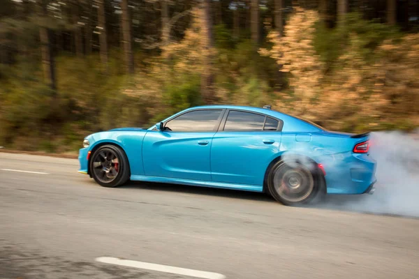 Light blue sport model car on the forest road — Stock Photo, Image