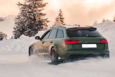 Yeşil off-road aracı. Ormana park etmiş kırmızı ışıkları var.