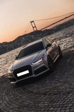 Limanda gümüş renkli bir araba park ediyor.