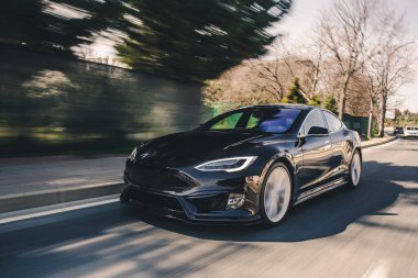 Tepelerden geçen siyah bir süvari, yol manzaralı.