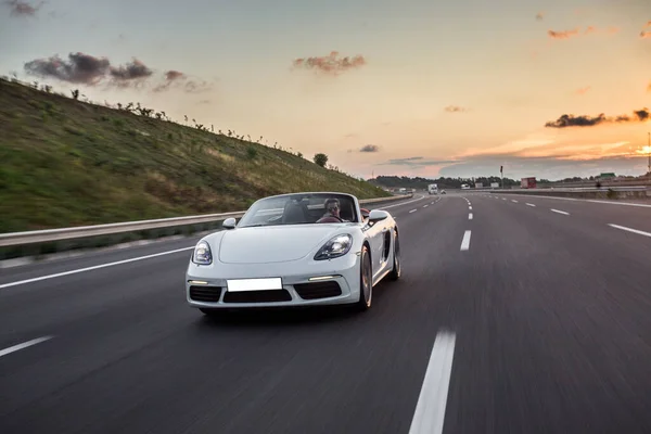 Fehér szuper modell kabrió autó vezetés az autópályán a naplementében — Stock Fotó