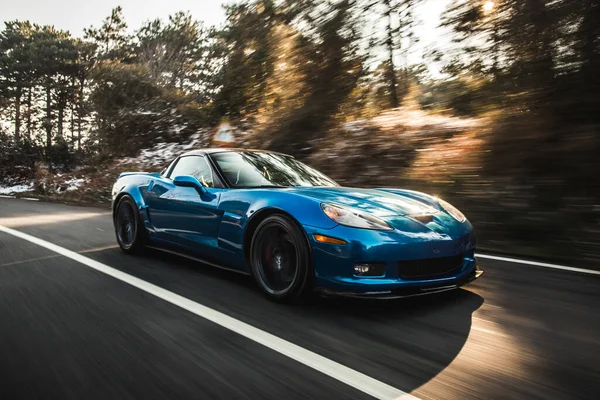 Blue brand sport model car speed test in the forest road under the ray of sun — Stock Photo, Image