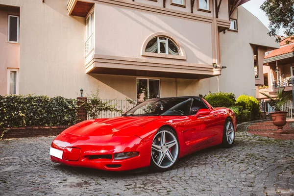 Coche deportivo rojo de lujo en la zona de aparcamiento frente a una casa — Foto de Stock