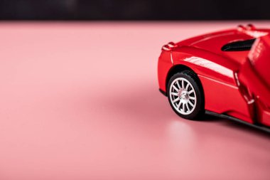 Pembeye izole edilmiş bir çocuk için küçük kırmızı bir araba oyuncağı.