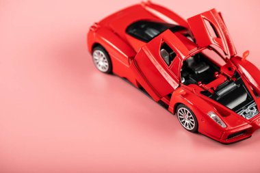 Pembeye izole edilmiş bir çocuk için küçük kırmızı spor araba oyuncağı.