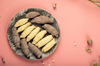 Kafkas tatlıları vanilya ve kakao hamurundan yapılmış pembe bir tabakta izole edilmiş.