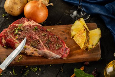 Tahtada çiğ et, soğan, patates ve ananas dilimleri.