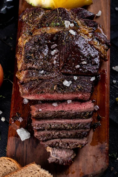 Sliced meat barbecue served with bread slices on a wooden board, top view — Stock Photo, Image