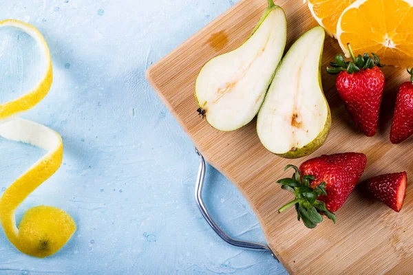 Strawberry, orange and pears on a blue background — Stock Photo, Image