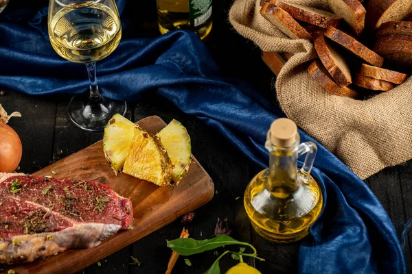 Carne cruda en una tabla de madera con hierbas y especias, servida con aceite de oliva — Foto de Stock