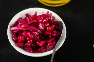 Beyaz çay tabağında marine edilmiş kırmızı nar tohumları.