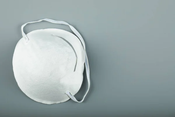 Una mascarilla médica moderna blanca sobre fondo azul — Foto de Stock