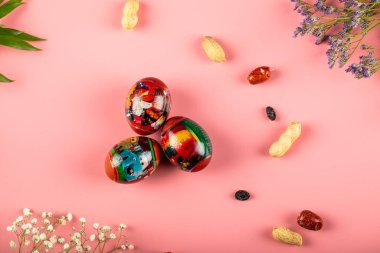 Geleneksel Novruz tatil fındıkları pembe arka planda süslenmiş yumurtalarla izole edilmiş.