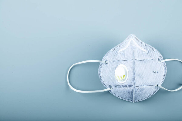 A blue medical face mask on blue background