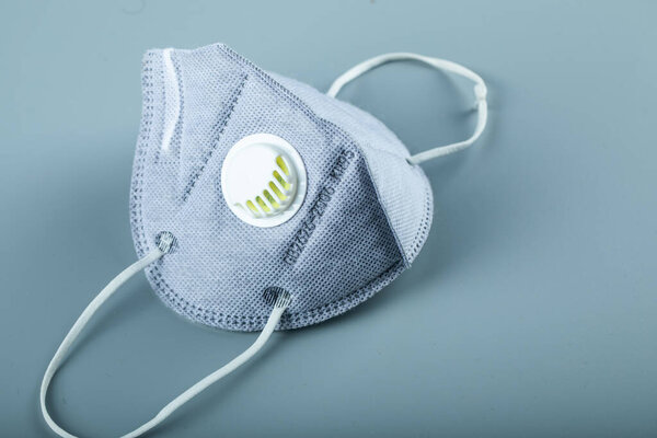 A blue medical face mask isolated on blue background, angle view