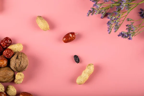 Nueces tradicionales de Novruz aisladas sobre fondo rosa decoradas con flores — Foto de Stock