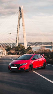 Kırmızı sütunlu tepenin üstünde kürek çekiyor.