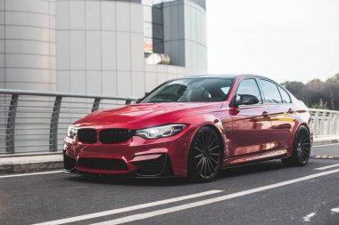 Modern bir konutun önündeki kırmızı evrensel SUv, gri şehir.