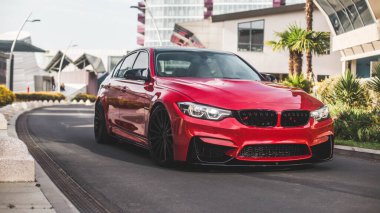 Boş şehir yollarında kırmızı model sedan.