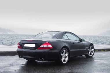 Siyah eski model sedan kışın sisli sahilde