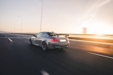 Günbatımında gümüş renkli yarış arabası