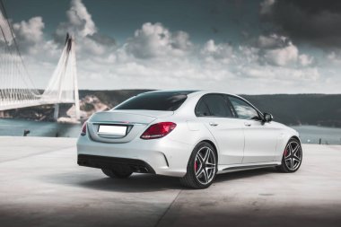 Sahilde park etmiş beyaz spor bir sedan.