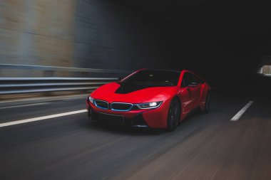 Otobandaki kırmızı spor araba sürüşü tünelden çıkıyor.