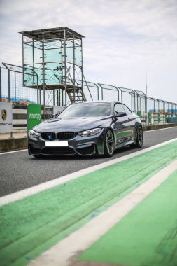 Yarış pistinde siyah spor araba.