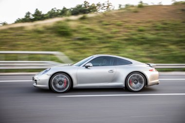 Dağ yollarında gümüş sedan, aşırı hareket, profil manzarası