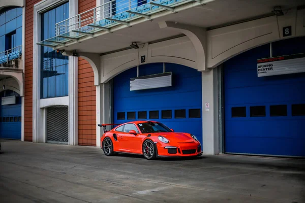 Oranje kleur sport coupé auto buiten een showroom — Stockfoto