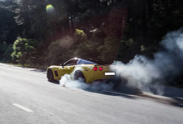 Rendimiento de velocidad de coche deportivo amarillo en el bosque con vapor de gas — Foto de Stock