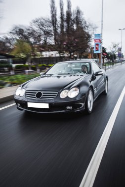 Otoyolda beyaz ışıklı siyah bir sedan.